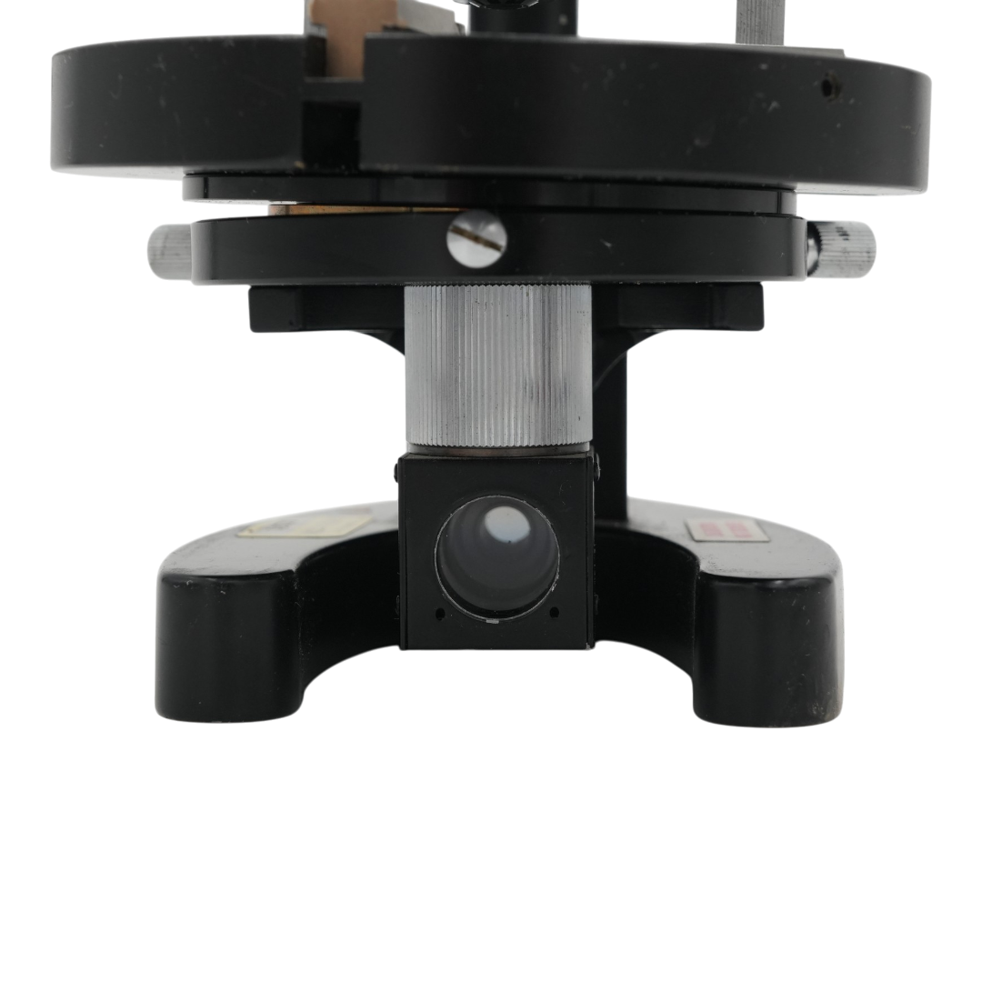 Close-up of a black and silver Pearl microscope prism assembly on a plain transparent background.