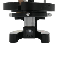 Close-up of a black and silver Pearl microscope prism assembly on a plain transparent background.